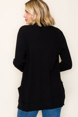 woman wearing a black long cardigan with side pockets, shown from the back