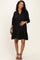 woman wearing a black maternity dress with three-quarter sleeves and a tiered skirt, showing her baby bump