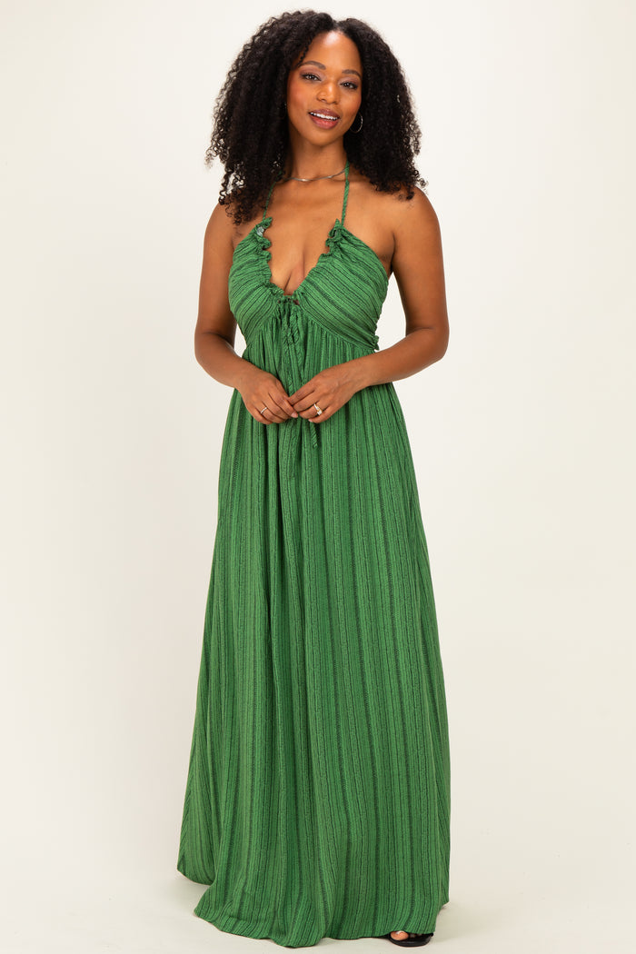 woman wearing a green halter maxi dress with a ruffled neckline and textured fabric