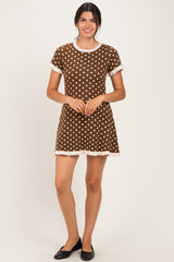 woman wearing a brown polka dot dress with short sleeves and ruffled hem