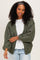 woman wearing a green oversized cardigan with balloon sleeves and a white t-shirt underneath