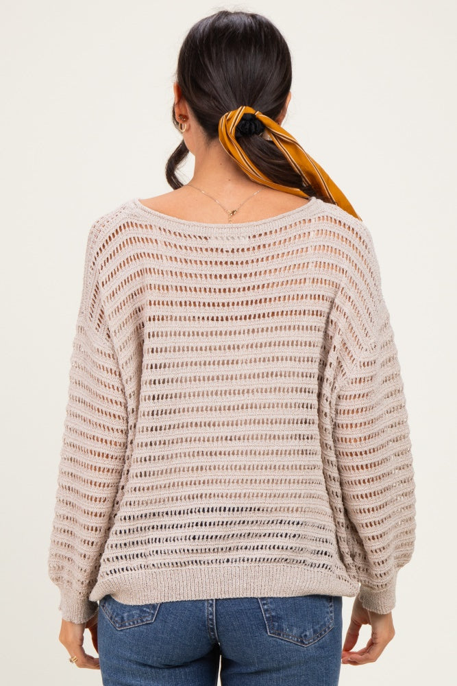 woman wearing a light beige striped knit sweater with a loose fit and boat neck, styled with a hair scarf