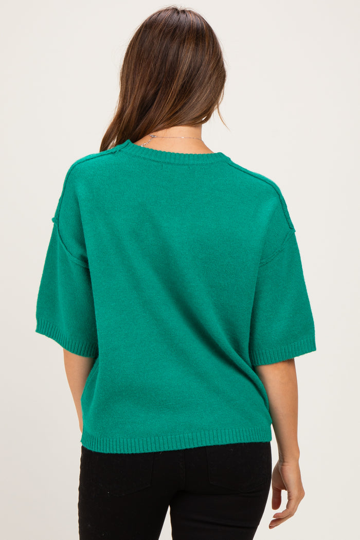 woman wearing a green short sleeve maternity sweater seen from the back