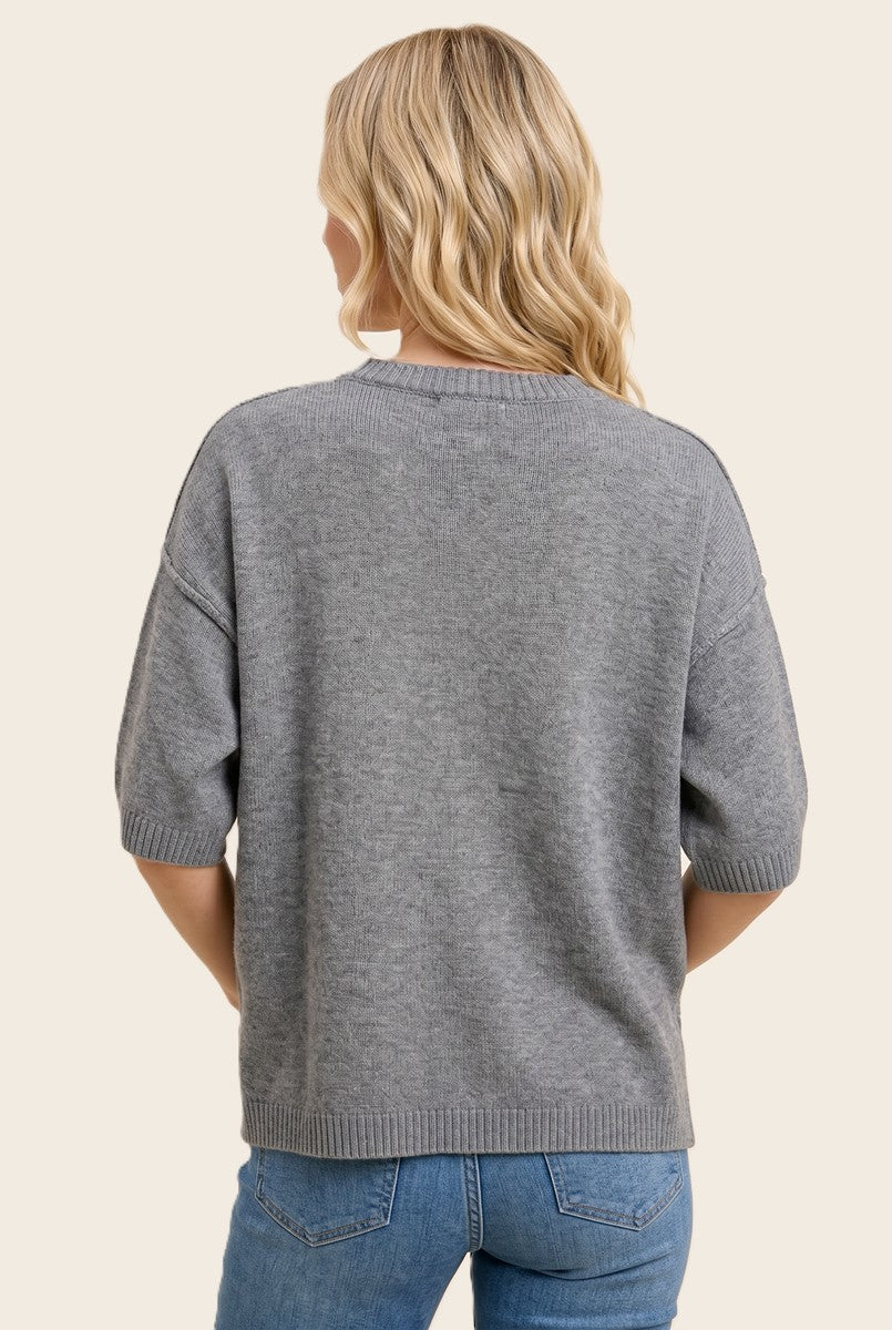woman wearing a gray short sleeve sweater with a relaxed fit, seen from the back
