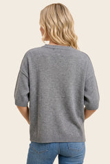 woman wearing a gray short sleeve sweater with a relaxed fit, seen from the back