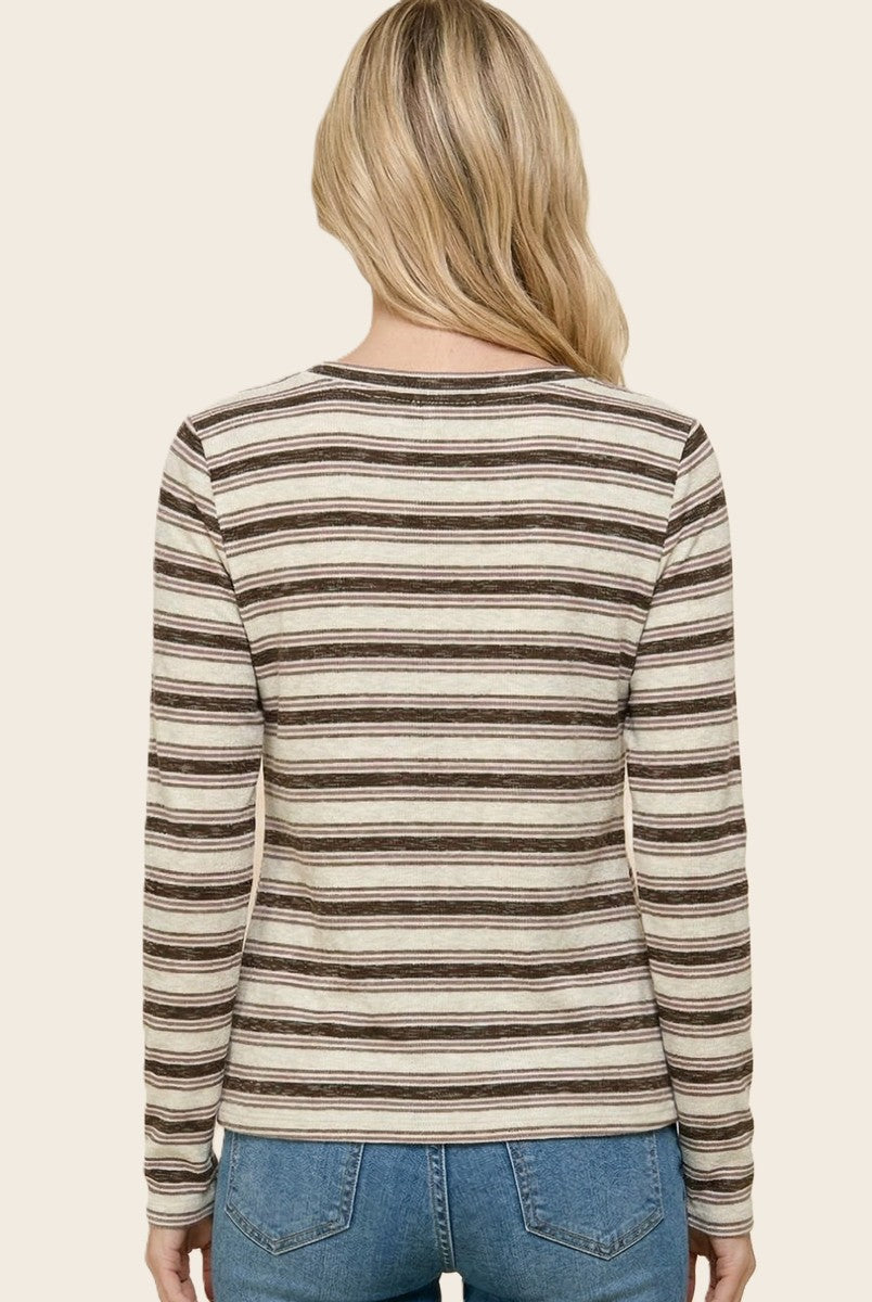 woman wearing a striped long sleeve top in beige and brown, seen from the back with light blue jeans