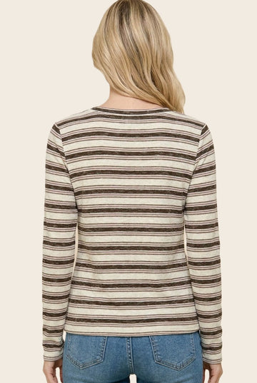 woman wearing a striped long sleeve top in beige and brown, seen from the back with light blue jeans