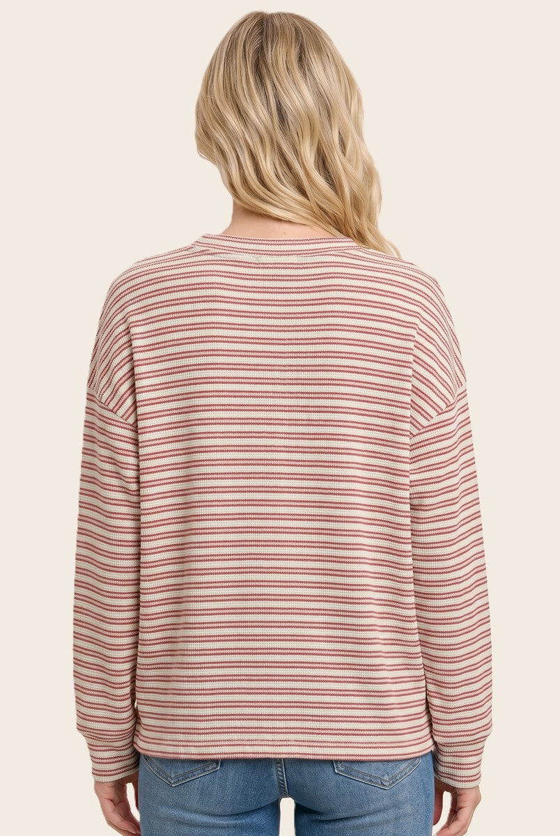 woman wearing a pink and cream striped long sleeve sweater with a relaxed fit, seen from the back