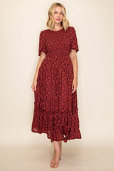 woman wearing a burgundy floral midi dress with short sleeves and a tiered ruffle hem