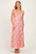 woman wearing a pink floral maxi dress with ruffled straps and a deep v-neckline