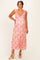 woman wearing a pink floral maternity dress with ruffled sleeves and a visible baby bump