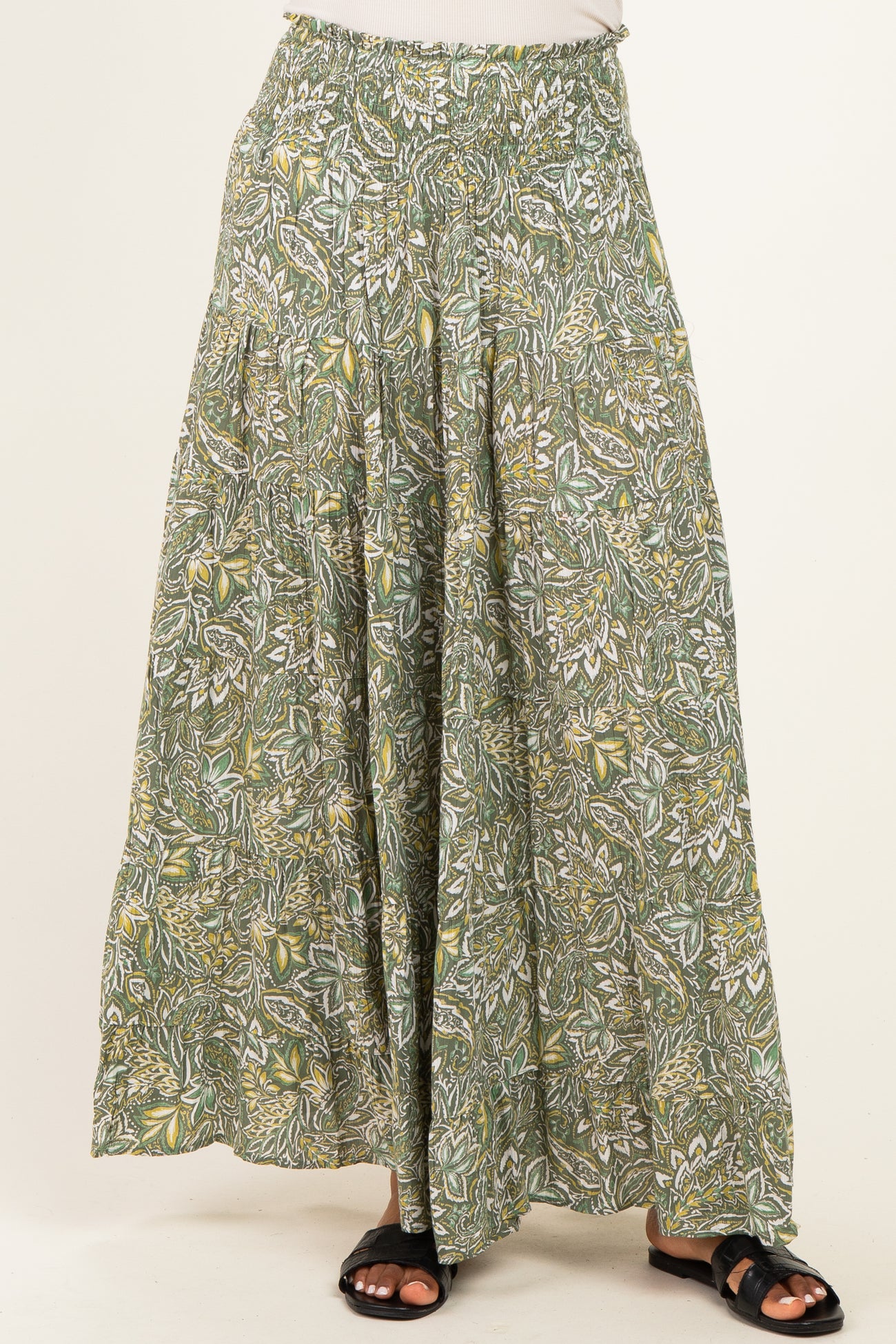 woman wearing a green floral patterned maxi skirt with an elastic waistband and flowing silhouette