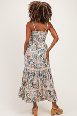 woman wearing a floral print maternity maxi dress with smocked bodice and tiered skirt, showing her back