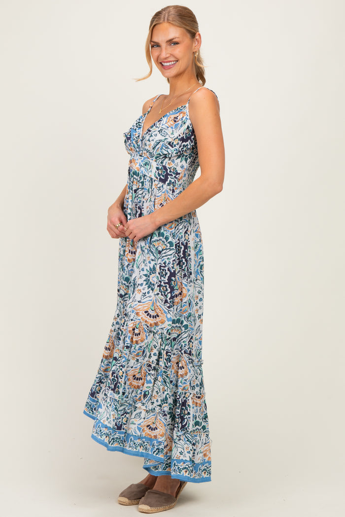 woman wearing a floral maxi dress with spaghetti straps and a flared hem, smiling and standing sideways