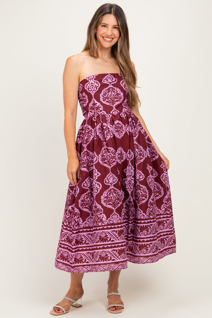 woman wearing a maroon strapless maternity dress with a purple floral print and a flowy full skirt