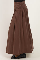 woman wearing a brown maxi skirt with a gathered waist and flowy silhouette