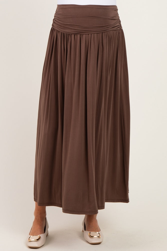 woman wearing a brown maternity maxi skirt with a gathered waistband and flowing silhouette