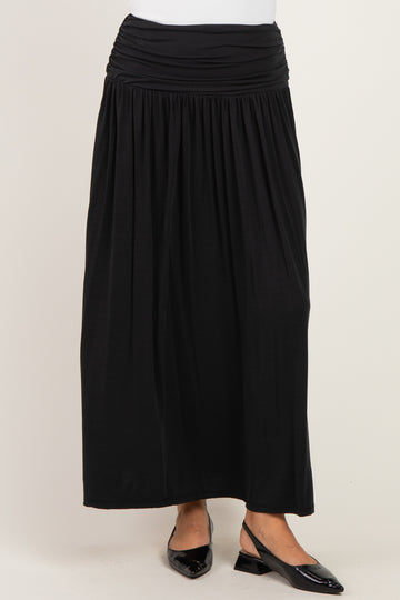 woman wearing a black maxi skirt with a ruched waistband and flat shoes