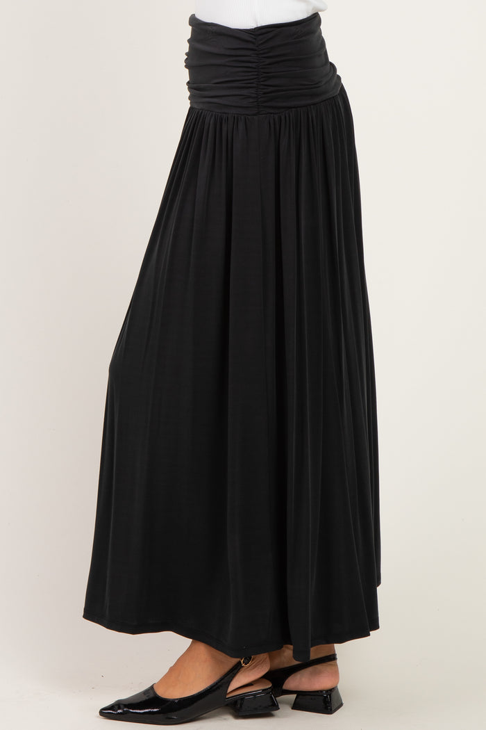 woman wearing a black maxi skirt with a ruched waistband and flowy silhouette