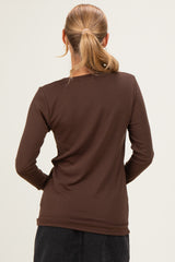 woman wearing a fitted brown long sleeve top, viewed from the back
