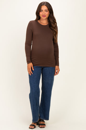 woman wearing a brown long sleeve maternity top and blue flare jeans with a visible baby bump