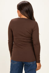 woman wearing a brown long sleeve maternity top, viewed from the back