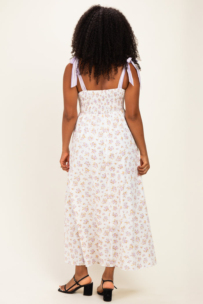 woman wearing a floral print maxi dress with back smocked detail and tied shoulder straps