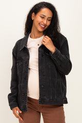 woman wearing a black maternity denim jacket over a light pink top and showing her baby bump