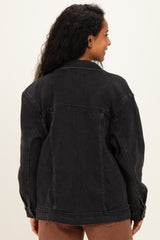 woman wearing a black denim maternity jacket, shown from the back with loose fit and dropped shoulders