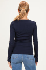 woman wearing a navy blue long sleeve maternity top, viewed from the back, paired with light blue jeans