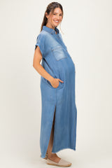woman wearing a light blue denim maternity dress with short sleeves and pockets, showing her baby bump