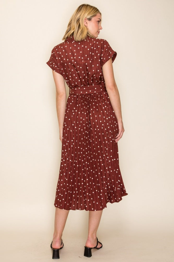 woman wearing a maroon polka dot midi dress with short sleeves and a cinched waist, shown from the back