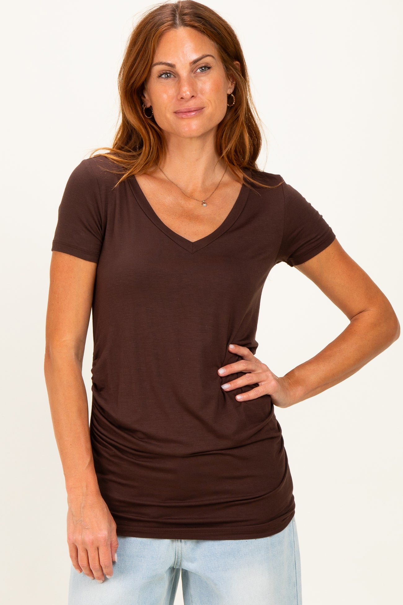 woman wearing a brown v-neck t-shirt with short sleeves and a relaxed fit