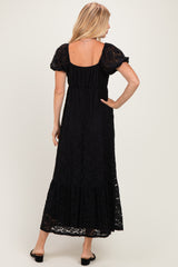 woman wearing a black lace maxi dress with short puff sleeves and a flowy skirt
