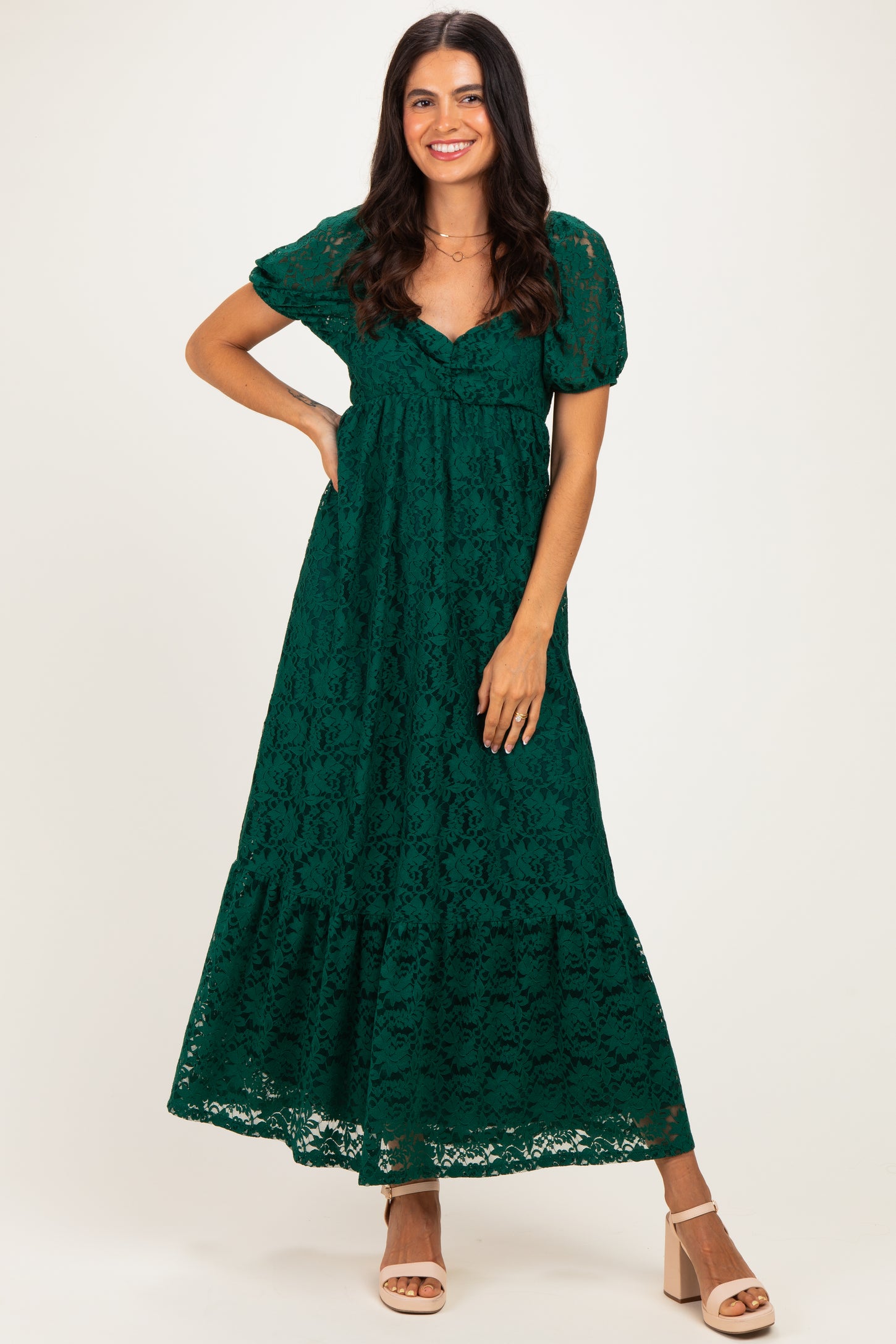 woman wearing a green lace maxi dress with short puff sleeves and a tiered skirt