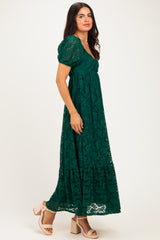 woman wearing a green lace maxi dress with puff sleeves and a flowing skirt