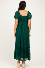 woman wearing a green lace maxi dress with puff sleeves and a tiered skirt, viewed from the back