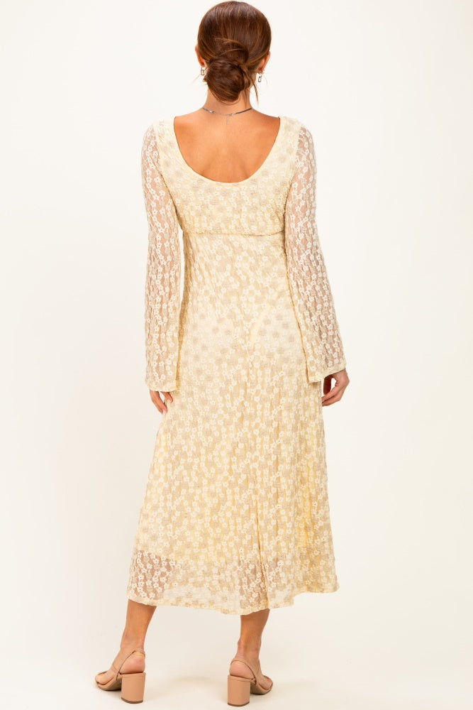 woman wearing a cream floral maxi dress with long sleeves, shown from the back