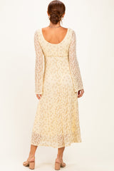 woman wearing a cream floral maxi dress with long sleeves, shown from the back