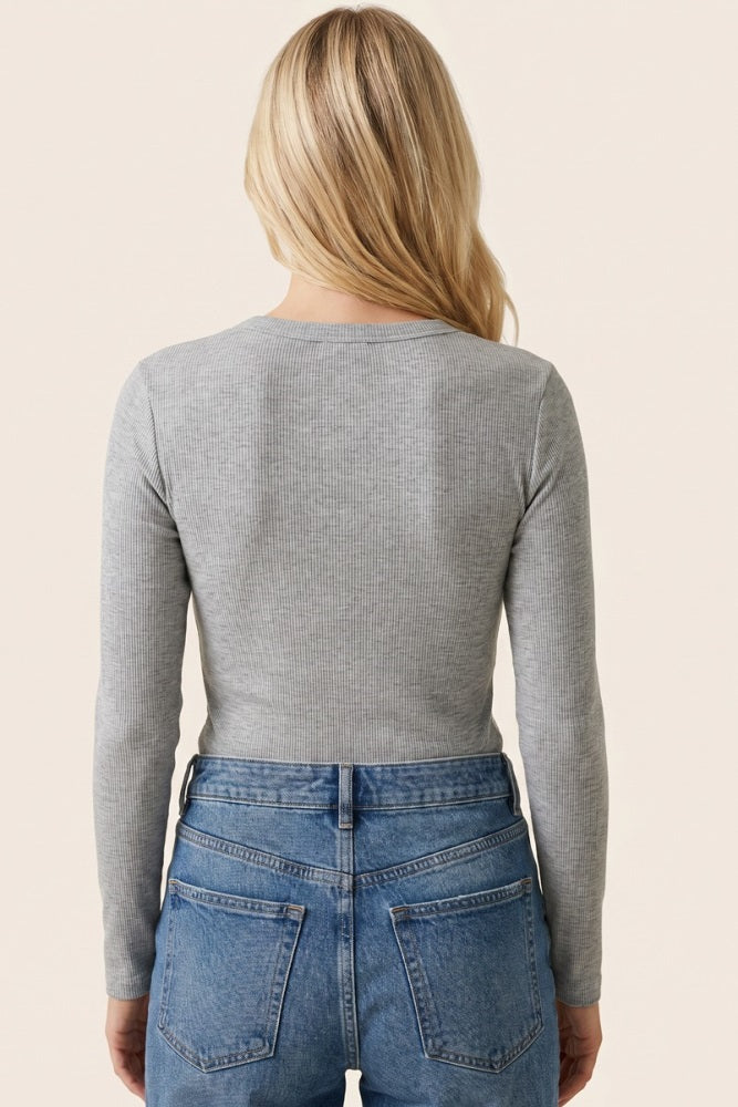 woman wearing a gray long sleeve ribbed top, seen from the back, paired with high-waisted blue jeans