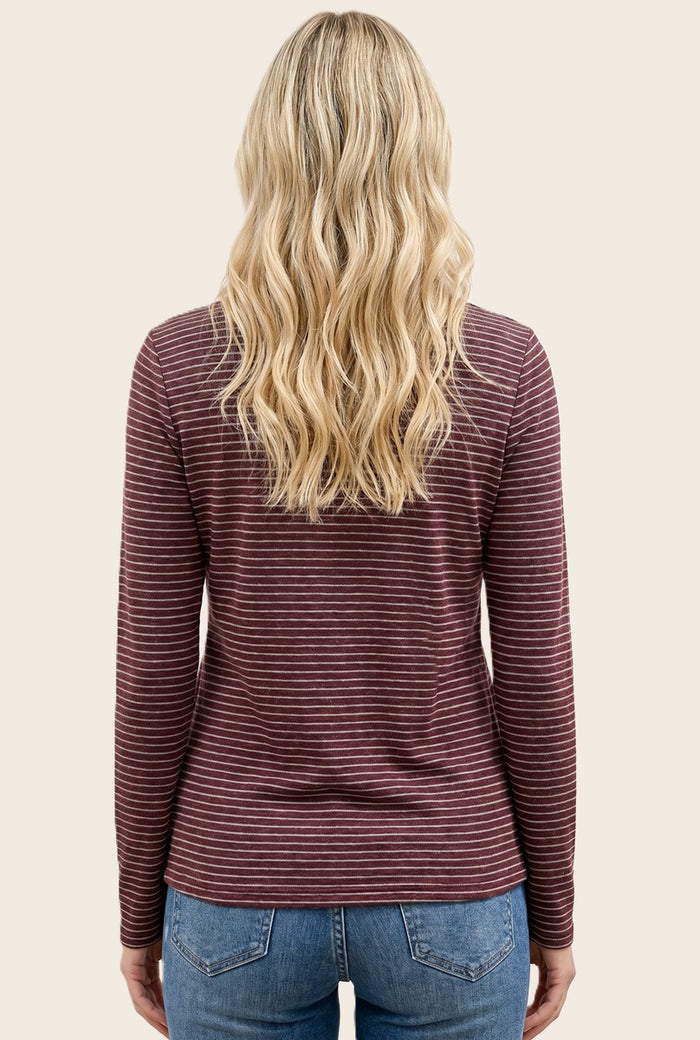 woman wearing a maroon and white striped long sleeve top with a round neckline and styled wavy hair