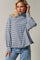 woman wearing a striped long sleeve turtleneck sweater with a relaxed fit and light blue and navy stripes