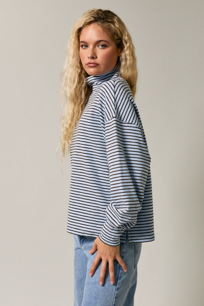 woman wearing a striped long sleeve turtleneck top with slightly oversized fit and casual blue jeans