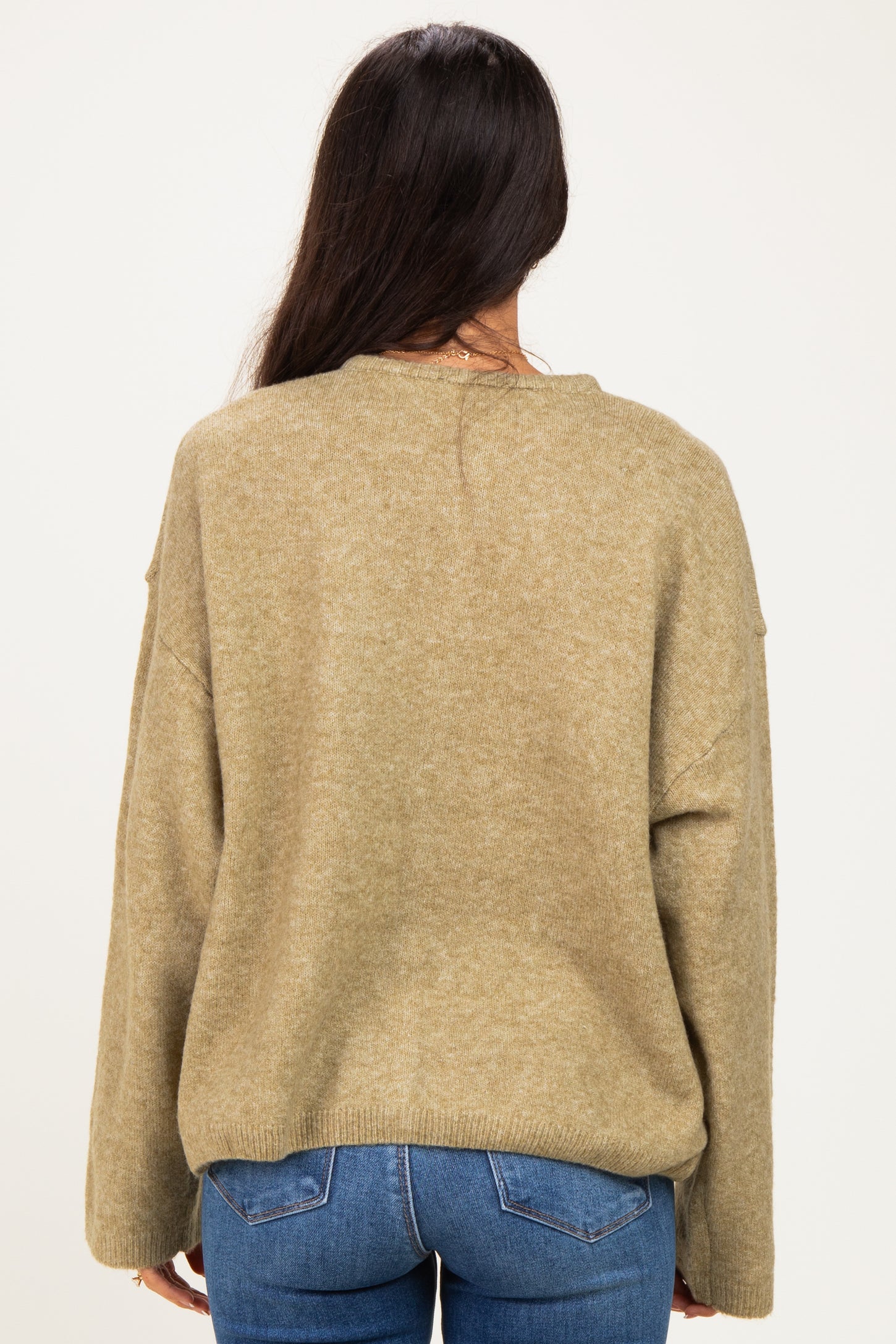 woman wearing a cozy olive green oversized sweater, viewed from the back with long sleeves and relaxed fit