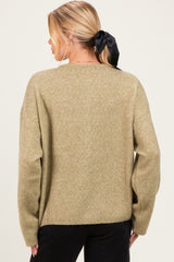 woman wearing a light green oversized maternity sweater, with a relaxed fit and long sleeves, viewed from the back