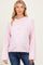 woman wearing a light pink oversized maternity cardigan with buttons, showing her baby bump, paired with denim jeans