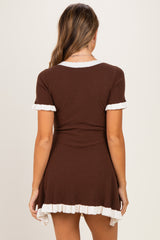 woman wearing a brown maternity dress with white ruffle trim and short sleeves, showing a fitted style from the back