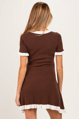 woman wearing a brown maternity dress with white ruffle trim and short sleeves, showing the back view