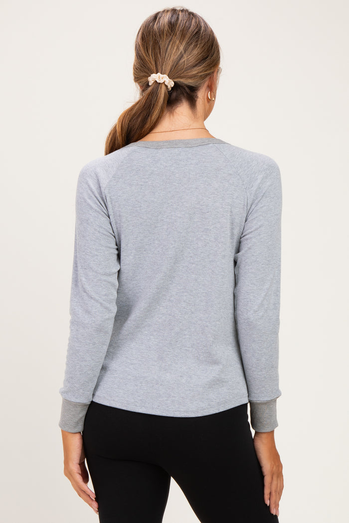 woman wearing a gray long sleeve maternity top with a relaxed fit, shown from the back