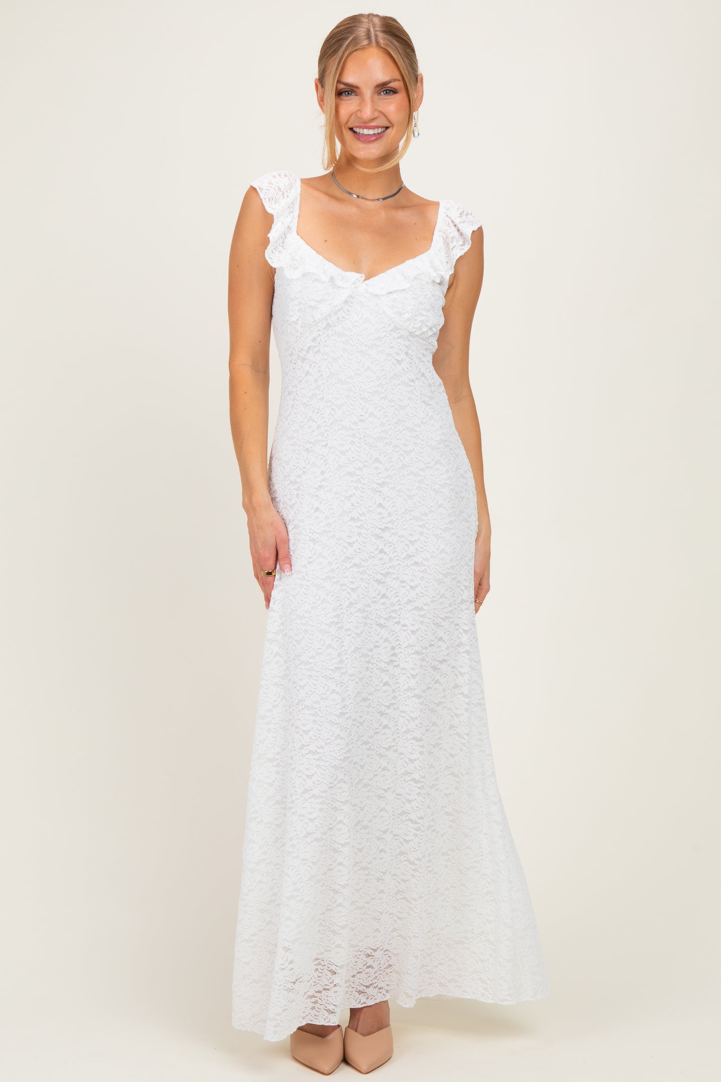 woman wearing a white lace maxi dress with cap sleeves and a plunging neckline